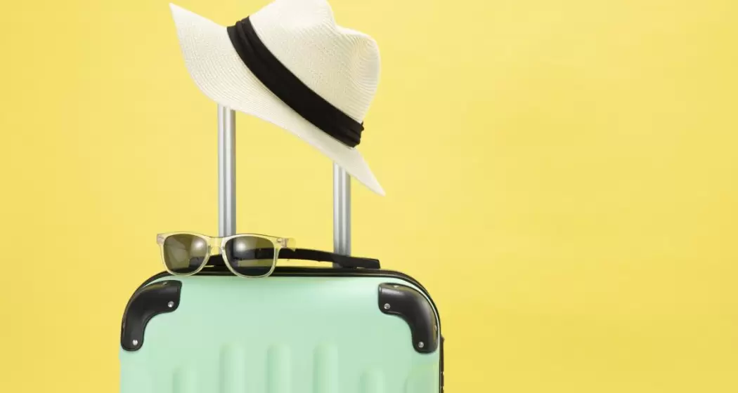 top-view-of-suitcase-sunglasses-camera-and-hat-on-yellow-background-vacation-concept