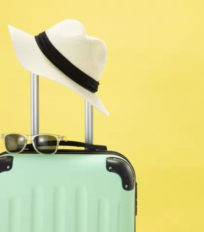 top-view-of-suitcase-sunglasses-camera-and-hat-on-yellow-background-vacation-concept