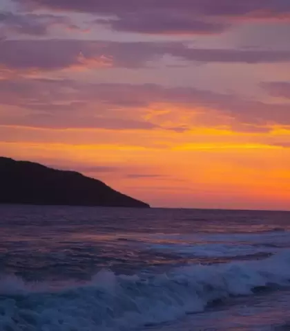 Atardecer en una playa del Pac�fico mexicano con olas marcadas y horizonte amplio.