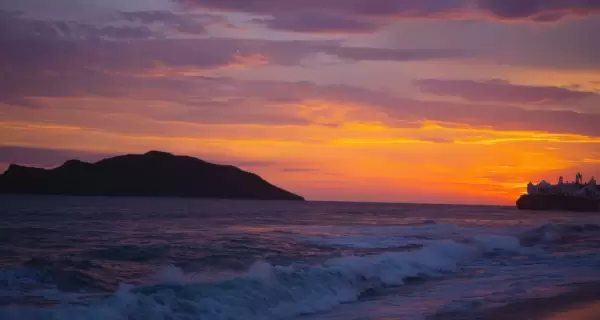 Atardecer en una playa del Pac�fico mexicano con olas marcadas y horizonte amplio.